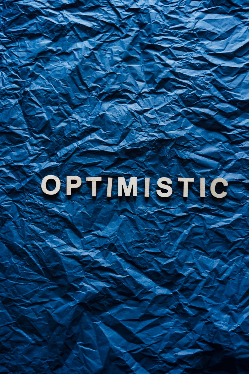 the word optimistic on crumpled paper